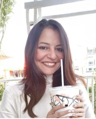 Janaína Nunes, irmã do prefeito Ricardo Nunes, toma bebida em copo plástico com canudinho