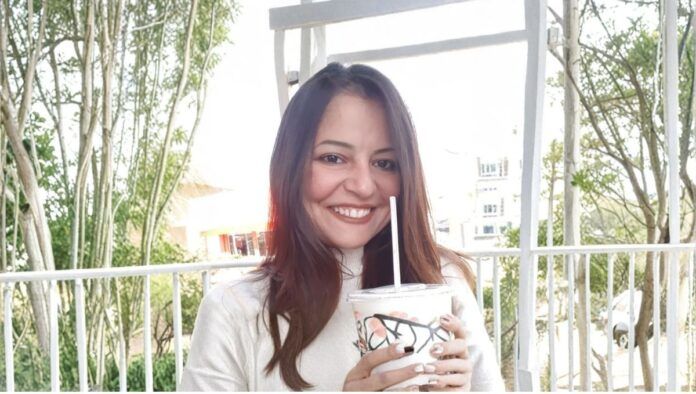 Janaína Nunes, irmã do prefeito Ricardo Nunes, toma bebida em copo plástico com canudinho