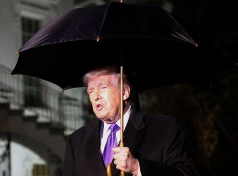 O presidente dos Estados Unidos, Donald Trump, segura um guarda-chuva enquanto fala com jornalistas ao deixar a Casa Branca com destino à Flórida