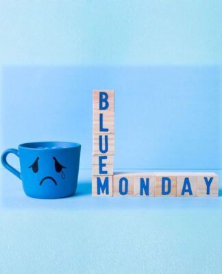 Imagem conceitual de Blue Monday, com caneca azul com cara triste e brinquedo de montar formando a palavra