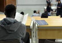 estudante negro lendo um livro na sala de aula