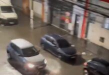 Carros passam por rua alagada em São Paulo