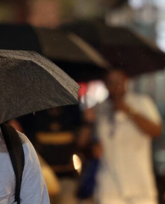 Pessoas durante chuva na Avenida Paulista.