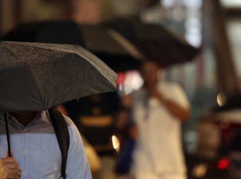Pessoas durante chuva na Avenida Paulista.