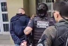 Policiais conduzem suspeito até a delegacia