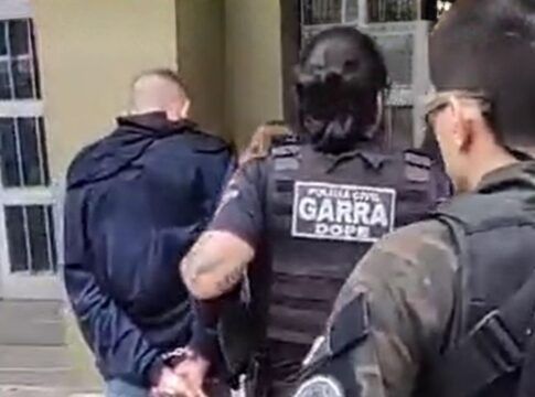 Policiais conduzem suspeito até a delegacia