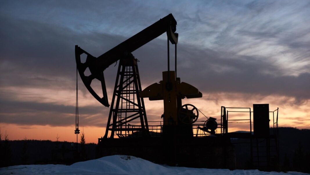 Pôr-do-sol sobre um campo de petróleo com uma bomba.