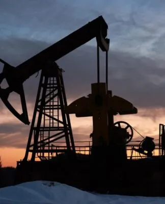 Pôr-do-sol sobre um campo de petróleo com uma bomba.