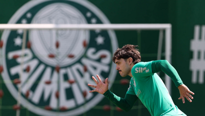 Maurício, do Palmeiras, treina na Academia do Futebol, e o símbolo aparece atrás dele na imagem