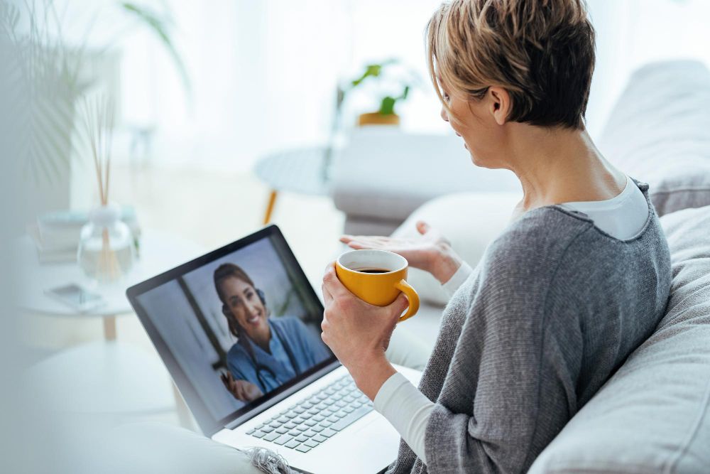 Mulher usando laptop e fazendo videochamada com seu médico