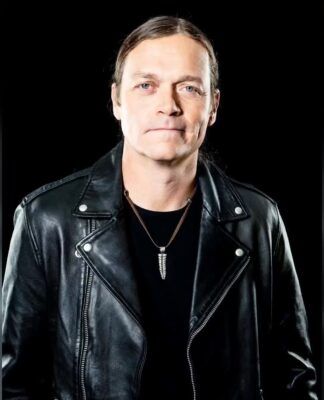 Foto de um homem em jaqueta preta: Brad Arnold, vocalista do 3 Doors Down