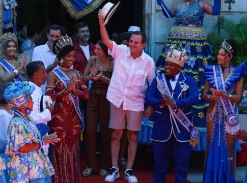 Eduardo Paes faz gesto segurando chapéu no carnaval