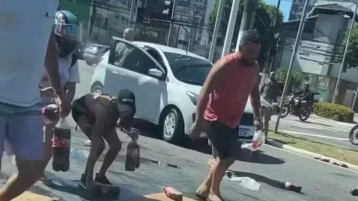 Carga de refrigerante cai de caminhonete e pessoas ajudam a recolher produtos em Vitória; veja vídeo