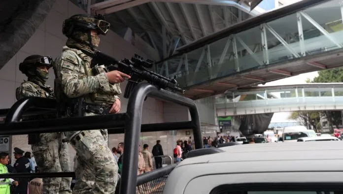 Membros da Marinha mexicana patrulham o Aeroporto Internacional Benito Juárez após as autoridades reforçarem a segurança em decorrência de bloqueios de estradas e ataques incendiários realizados pelo crime organizado em diversos estados, após uma operação militar na qual, segundo uma fonte do governo, o narcotraficante mexicano Nemesio Oseguera, conhecido como 