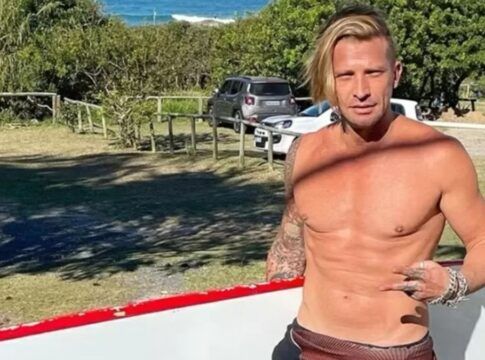 Ex-modelo carrega prancha de surfe