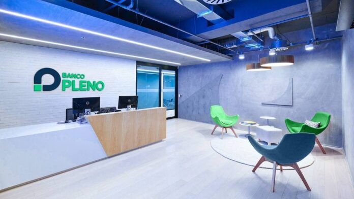 Imagem do escritório do banco, com cadeiras e computadores