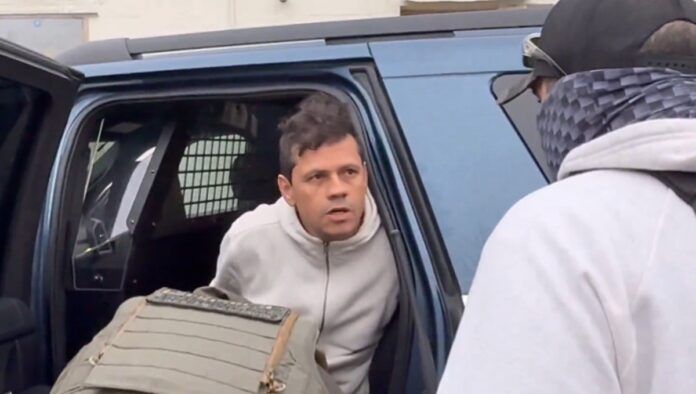 Brasileiro em carro, algemado por agentes do ICE