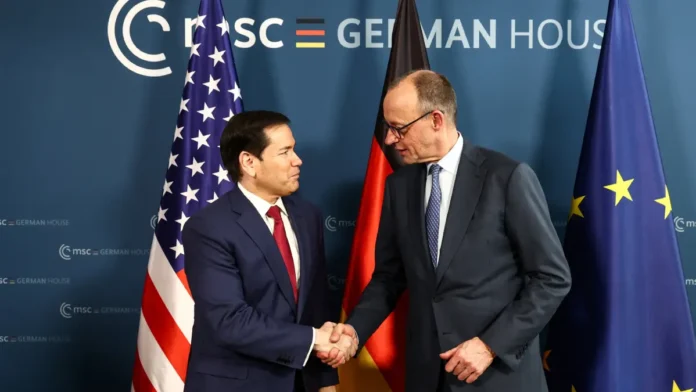 Dois homens apertam mãos em frente às bandeiras de Estados Unidos Alemanha: Marco Rubio e Friedrich Merz