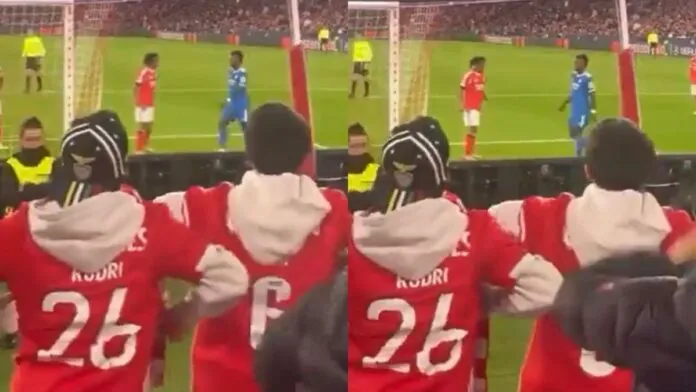 Montagem com duas imagens de baixa qualidade registradas da arquibancada de um estádio. Em primeiro plano, torcedores vestindo casacos vermelhos gesticulam em direção ao campo. No gramado, ao fundo, dois jogadores — um de uniforme vermelho e outro de azul — estão próximos.